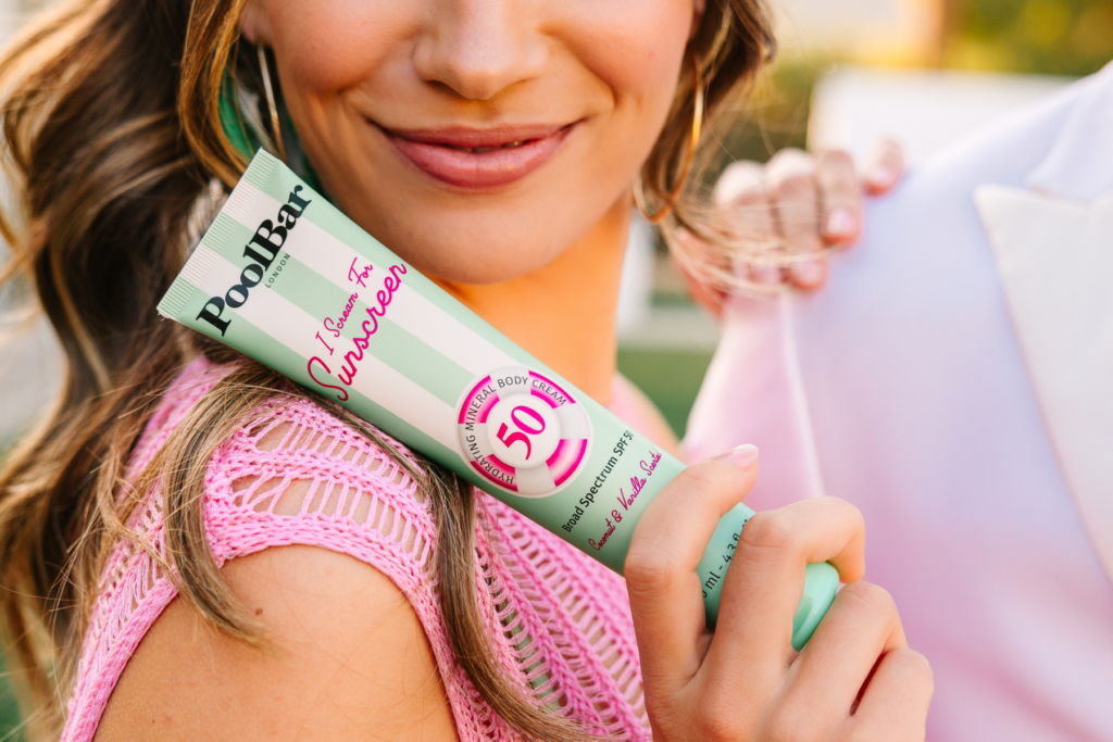 Close up of woman smiling holding Poolbar sunscreen